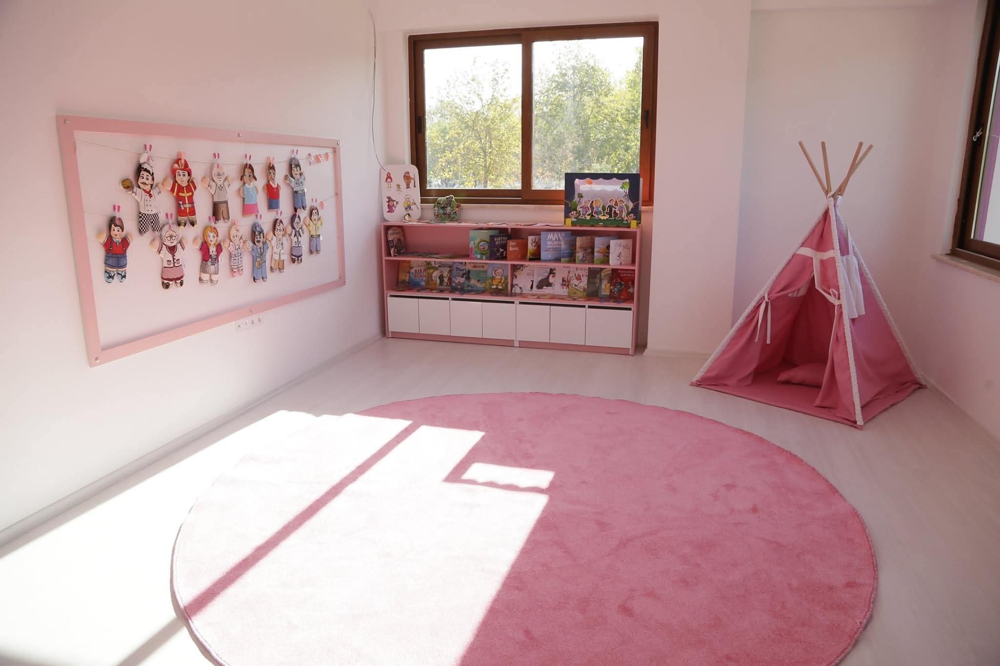 Pembe çadır ve kitaplıkla okuma köşesi