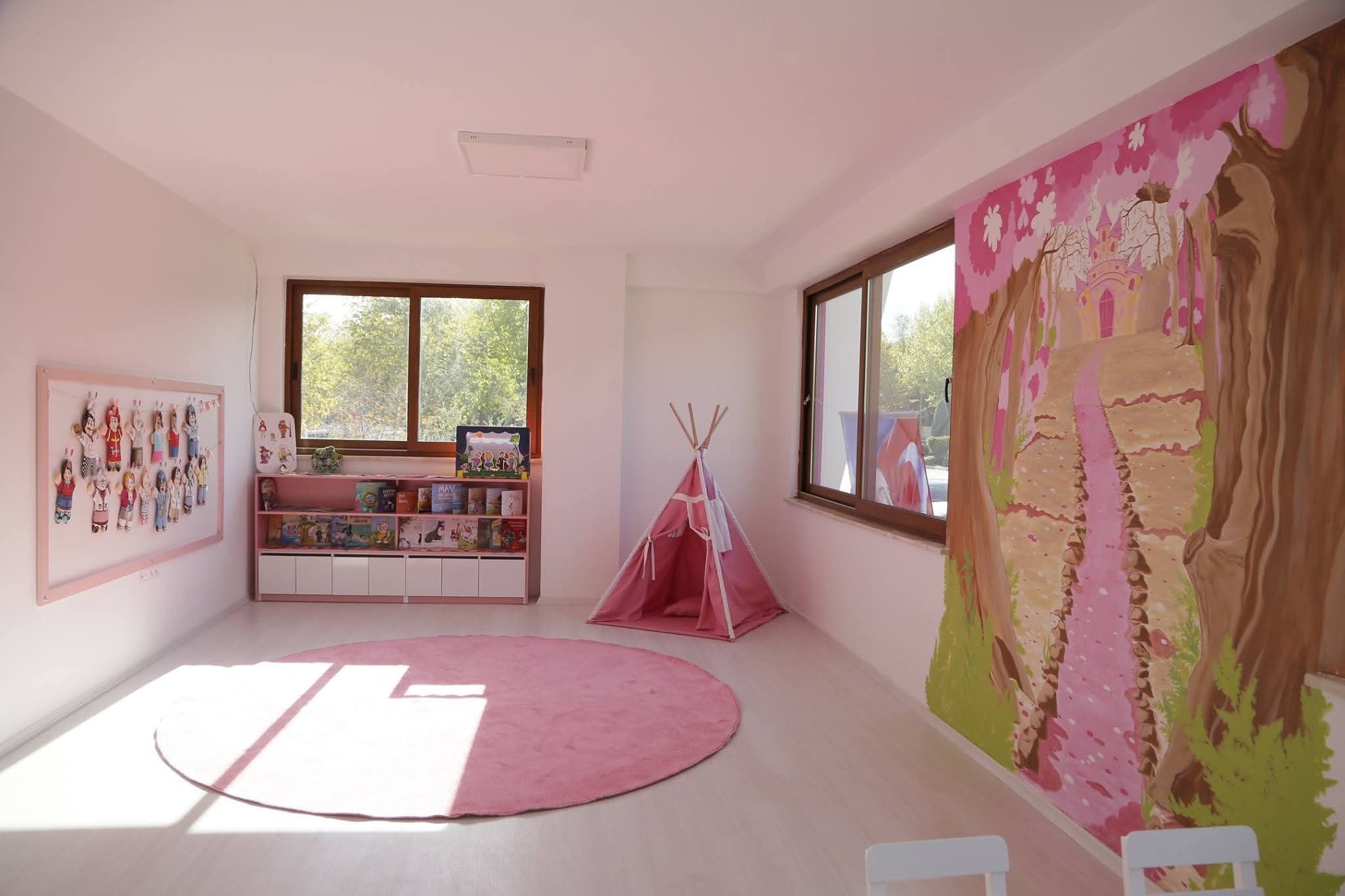 Pembe sınıfta çadır, halı ve kitaplık